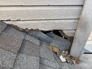 Damaged siding and an opening beside a roofline